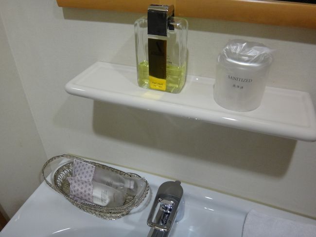 羽田空港国内線第1旅客ターミナルにあるクレジットカード会社ラウンジ<br />『エアポートラウンジ（中央）』のシャワールームの洗面台にあるアメニティの写真。<br /><br />資生堂のヘアリキッド、ヘアブラシ、レザー、歯ブラシ