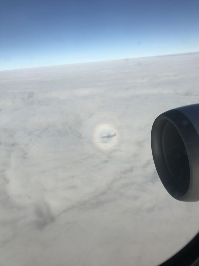 虹と飛行機の影<br />厚い雲の上っていうことは下は曇天…