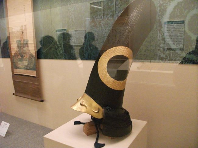 こちらは加藤清正着用の烏帽子形兜<br />「南無妙法蓮華経」とお題目を書いた数百枚の紙を張り合わせて長烏帽子をつくり黒漆の下地に銀粉を塗って作ったものです。側面の金の輪っかは清正の家紋、蛇の目です。