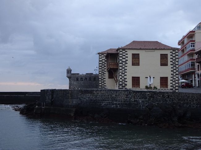 入り江の向こう側には、目立つ黄色の建物と哨兵台の突き出した要塞があります。