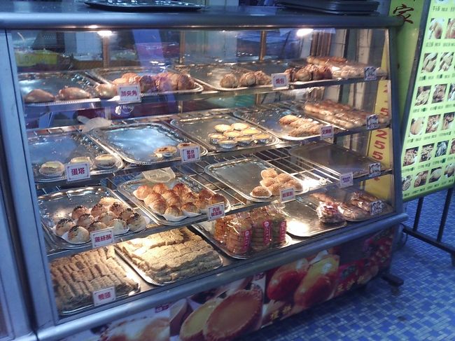 LOU　WONG付近のお菓子屋さん<br /><br />お腹は満腹状態ですが、エッグ・タルトを見つけると、2個買っていました。1個はホテルで食べたのですが、残りの1個はさすがに残してしまいました。<br /><br />エッグ・タルトといえども、結構なボリュームがあります。