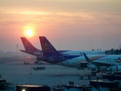 ゲートで待つ間、ちょうど日の出と朝焼けを見ました。

ゲートまで行って明るくなったころ、搭乗が始まったのですが、先頭で行った人たちがなぜか戻ってきた。何かの不備なのかなと思いつつ、10分ほどで搭乗再開。まあ、急ぐ旅ではないので、ウチは別に構いませんが。