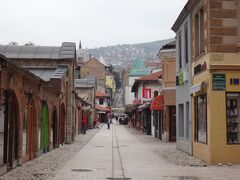 商店が並ぶ小さな通りの奥に坂道と山が見える、サラエヴォの街のイメージ。
左側はガジ・フスレヴ＝ベグ・バザール。
このあたりやたらとガジ・フスレヴ＝ベグ何とかという名前の施設が集中しています。