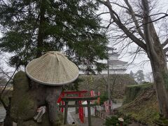 お稲荷さんの狐もかさをかぶり、城を見つめています。