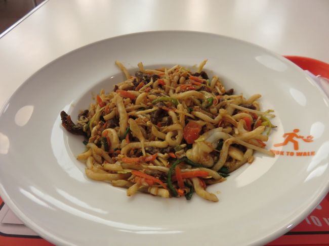 ホテル隣のフードコートで焼うどんもどき料理を注文する<br />ヘラでうどんをプツンプツンと切る