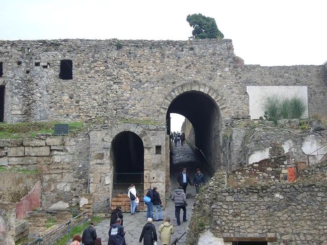 入口ゲートを通ると、遺跡が見えてきます。大きな石造りのアーチを抜けて、ポンペイの街に足を踏み入れました。