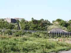 避難シェルター（写真右）と平成新山観測台（写真左の石垣）です。
この周囲の植物や木々は火砕流や火災サージで焼きつくされました。それが現在ではこんなに緑豊かな場所へと甦っています。
観測台の奥の木々の中には火砕流などで黒く焼かれた木がありますが、それらの木では新しく芽が出てそれが枝となり、葉が生い茂って見事に蘇生した姿を見せてくれています。
それらの木からは植物の生命力の力強さを感じることができました。
