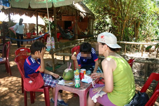 見学が終わると、入口付近のスタンドで休憩。<br />何件か並んでいたが、ガイドさんのなじみの店に入った。<br /><br />ベトナム成人男子、働かないなーーｗ<br />昼間っから、ハンモックでお昼寝中。<br /><br />夫と子供がトイレ（施設のトイレは綺麗）に行っている間、先に車に戻った時、老婆が車によって話かけてきた。<br />震える片手に乾燥した葉っぱを持って何か言っていたが、ベトナム語なので、勿論何も解らず。<br />ガイドさんが戻ってきて、お金を渡して追い払った。<br /><br />戦争未亡人だそうだ。収入がないので野草を積んで乾燥させた物を売っているとか。<br />戦争関係の観光地だから観光客相手に商売（？）しているのかもしれないけれど、やはり気まずい。<br />今日は私たちの他に観光客がいなかったから、こんなあがりだっただろうけれど、<br />大勢の観光客がきて、それなりの収入があって、裏でニヤリとしたり顔で笑っているお婆さんであった欲しいと願った。<br />
