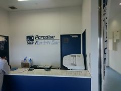 楽天トラベルから予約しているパラダイスレンタカーでクルマを借りるために、シャトルバスでレンタカーステーションへ。空港のすぐ近くですね。ほとんど隣の敷地みたいなもの。
荷物が少なく、バスを5分ぐらい待つなら歩いた方が早いかもしれませんね。

レンタカーステーションには、日産レンタカーや、タイムズレンタカーなど、いくつかのレンタカー会社が軒を連ねています。ここを使っているのは、そこそこ大手・中堅というところですね。

パラダイスレンタカーは、口コミなどを見ると、スタッフの対応がイマイチみたいなことが書いてあったりしましたが、空港の受付スタッフも、貸出カウンターのスタッフも、まったく問題はありませんでした。
ただし、カウンターは一人で対応しているので、お客さんが重なるとかなり待たされることになるかもしれません。