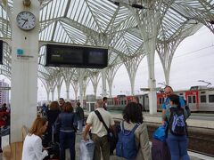 結局、私たちが乗る予定だった列車は、15分ほど遅延した後、予定されていたのとは違うプラットホームに到着し、そのままお客さんを乗せて行っちゃいました。　その情報も、オリエンテ駅ではまったくなかったので(アナウンスくらいはされたかもしれないけど、ポルトガル語なので分かるはずもなく)、結局乗りはぐってしまいました…!　ポルトガルに到着していきなりこんな事が起こるなんて～。　列車トラブルと言えば…よみがえる数年前のイタリア旅行とドイツ旅行の悪夢(苦笑)。

白いスーツの女性は本当に親切で、一緒にインフォメーション窓口にも行ってくれて、次の列車に振り替える交渉まで手伝ってくれました。　ポルトガル人、親切すぎるでしょ!!　この写真にもベンチに座ってる白いスーツの女性写ってます。

結局、次の特急列車の発車は2時間半後!　大きな荷物が手元にあったので、買い物とかに出かけることも出来ず(目の前が大型ショッピングモールだったけど)、駅でずーっと待ちぼうけ状態。　あぁぁ、この時間が本当にもったいない!　列車の遅延が最初から分かっていれば、もっとちゃんとしたカフェに座って朝食食べられたのに!