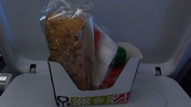 3時間くらいのフライトだけど軽食が出ました。<br />パンの後ろに隠れているジュースがおいしかった。<br />サンドイッチもおなじみのパサパサのパンだけど普通に美味しかった。