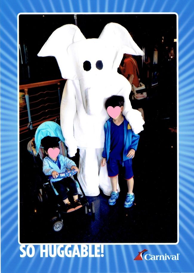 船に乗り込んだとたん、タオルアートの象の着ぐるみがお出迎え。そこを船のスタッフが撮った写真がこれ。クルーズ旅行では船会社のスタッフが色んな機会に写真を取り、それをあとで販売しています。気に入ったら購入するというスタイルです。「とっても抱きしめたくなる」というキャッチコピーが写真下に入っていますが、着ぐるみが不気味すぎて子供たち緊張気味（汗<br />そのギャップが面白かったのでお父さんは写真を購入しました♪