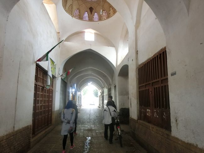 良かったらウチまで来ないか？と誘ってくれたので、雨が止むのを待って、有難く付いていくことに。<br /><br />広場に面して立っているミナレットの奥側は、バザールになっていました。<br />といってもあまりお店は開いていないようだけど。