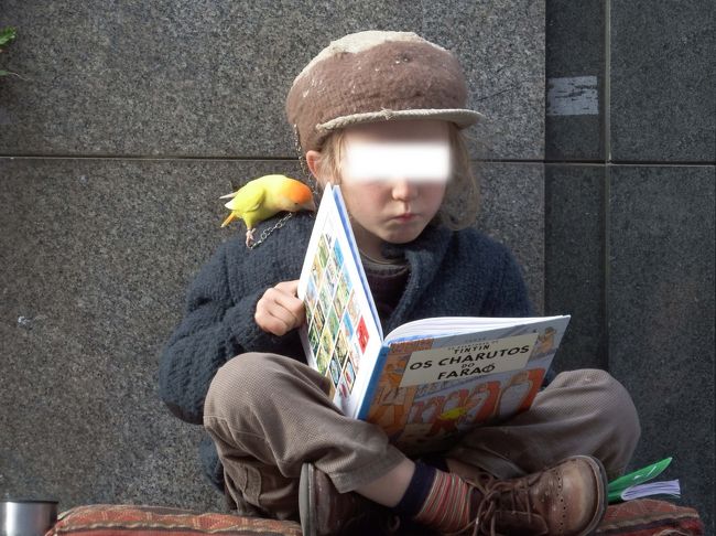 インコを肩に乗せ、一心に絵本を読んでます。<br />帽子も、着ている服も、靴下も、靴も、<br />ファッションがクラシックで、可愛すぎるゥ～！<br /><br />子供を大道芸の一部に利用して、いいのかなぁ～・・・・。
