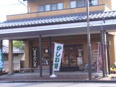 再び駅前の商店街に戻ってきました。
お次は直江津を代表する和菓子屋さん、三野屋。
放浪記にも登場したというお菓子『継続だんご』を作っているお店です。

まだ朝なのでお土産としては購入できませんが、せっかくなので1本いただきましょう。
お店の前にベンチもありますし、食べる場所は確保できそうです。