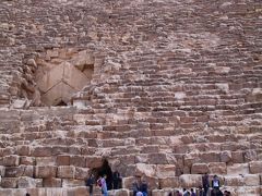 まずは、クフ王のピラミッドへ入ることにしましたが、入り口がオープンするのは１時からということで、30分くらいありますが、待ってみることにしました。
写真下法にある穴が観光用入り口で、左上にある三角形のところが本来の入り口です。しかし、そちらからは入ることができません。
ピラミッドの大きさは周囲にいる人と一つ一つの石の大きさを比べてみればわかるように、本当に巨大です。