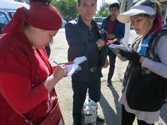 ウズベキスタン側の国境の町、チェルニィエフカに到着。乗り継ぎがうまく行ってホテルを出てからまだ１時間も経っていない。
(カザフスタンまでの移動方法についてはいろんな方々の旅行記を参考にさせて頂きました、ありがとうございます。)
ここでウズベキスタン出国の為の税関申告書を書かなくてはならないのだが、一緒に行こうと言ってくれた親切なおじさんに従って代筆屋さんにお願いした。所持金や貴重品を記入してくれる。わずか1,000スム(15円程度)で煩わしい書類の記入から解放された。
後ろの強面の人が人が親切なおじさん。カザフスタンのシムケントまで一緒に行ってくれた、感謝！