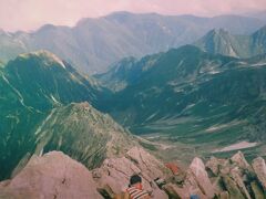 槍ヶ岳頂上よりの喜作新道（右側は上高地より上ってきた道。山小屋が２つ見えます。中央左はヒュッテ西岳。奥の山々は常念岳等の稜線）　