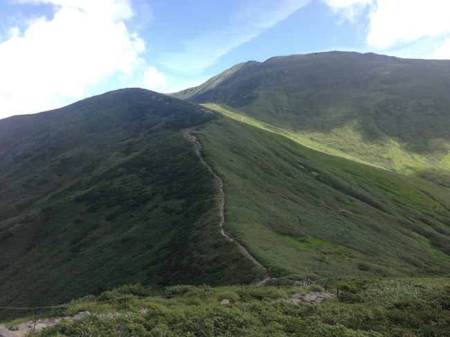 姥が岳山頂は木道のような木のベンチが並んでいて見晴らしも良く、麓の庄内平野から鳥海山まで望むことができます。この先向かう月山山頂方面を眺めると、知らぬ間に雲がモクっと出始めています。