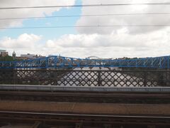 10:48頃、街並みが都会的になってきました。

この川はタイン川。
そして、青い橋の奥に見えるアーチ川の橋は、タイン橋。1928年の完成当初は、世界最大のアーチ型の橋だったそうです。