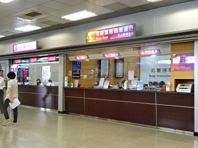 早速両替。最近のお気に入りは、左側びある台湾銀行での両替です。お札が比較的きれい、または新札の事が多く、コインもきれいなピカピカしたものが貰える率が高いからです。<br />手前にある右側の銀行は、到着便が来ると大行列になりますが、ちょっと曲がった台湾銀行はいつも人が少なくて、次に人が並ぶことも少ないですから、焦らず両替内容の確認をすることができます。レートはどこもそんなに変わりませんので。<br />私はきれいなお札がもらえる方が嬉しい派です。