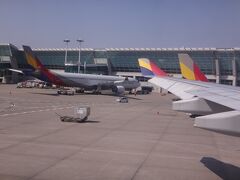 韓国・ソウル 仁川国際空港の写真。

東京（成田国際空港 12:30発）～ソウル（仁川国際空港 15:00着）のアシアナ航空
OZ101便は仁川国際空港に到着しました。ドアオープンは15:10。
搭乗ゲート43番に到着。

アシアナ航空機が並んでいます。

私たちが搭乗した機材は古いしボロイし、成田空港からソウルまでアルコールの
サービスはないし非常に残念でした（泣）