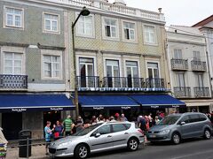 ジェロニモス修道院に向かって右に行列のお店があります。
ここはパステイス・デ・ベレン
ポルトガル名物のパステル・デ・ナタと呼ばれるエッグ・タルト。
国民に愛されるおやつで、絶大な人気を誇ります。パステル・デ・ナタの名店と評判なのが、こちらのお店です。
