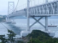 駐車場でバスを降り、始めに大鳴門橋のたもとにある土産物屋「若山商店」の店内から渦潮を見ました。

お店のおばちゃんスタッフが説明してくれます。
「船も出ていますが、２番目の橋脚と３番目の橋脚の間に見えているのが渦潮です」

おー、あれか～。
水を巻き込んでいるような立体感はありませんが、なんか白波が立っています。

続けて、がっかりする一言。
「皆さん、うず潮はいつ来ても見られると思っていらっしゃるようですが、うず潮を見たいなら、次は大潮の日に来てください。いいですか？皆さんが期待されているようなうず潮は、大潮の日でないと見られないんです」

つまり、今日はだめだってことなんですね。
私、潮見表を調べて来ました。
この日は大潮のはずなんですけどね～。