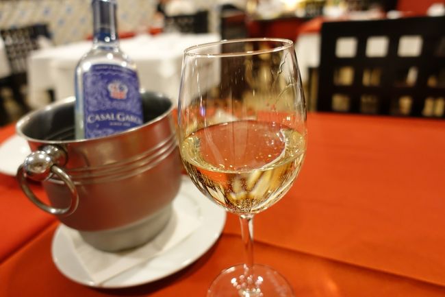 VINHO VERDE（ヴィーニョ・ヴェルデ）という緑のワイン。<br /><br />完熟前の若いブドウで作られた微発泡のワインで、爽やかですっきりした味なので冷やして飲むととってもおいしい！<br /><br />滞在中はこればっかり飲んでました。<br /><br />と、ここでお隣のテーブルに座ってらっしゃった年配のご夫婦からお誘いを受け、テーブルを移動してご一緒することに。<br /><br />インド系のご夫婦で旦那様はムンバイ育ち、奥様はロンドン育ちで、今はニューヨークにお住まいだそう。<br /><br />仕事で2年間深センにいらっしゃったこともあり、東アジアにも詳しい方々で、もちろん日本にも来たことがあるとのこと。<br /><br />旅の話はもちろん、奥様が私の仕事内容にも興味を持って下さったのでそのお話や、日本滞在中のエピソードなど、とっても話が盛り上がりました！<br />（もちろん大好きなNYについても！）<br /><br />1人もくもくと食べる予定（←w）が思わぬ出会いでとても楽しい時間となりました。<br />※話に夢中でお食事の写真を撮り忘れましたが、ポルト名物の「トリパス」という煮込み料理をいただきました。