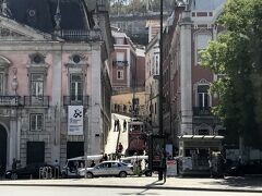 アパート近くのフォス宮にあるInfoに来て、リスボアカードの24時間券を買いました。大人19ユーロ、子供12ユーロでした。
Infoは日本の銀行みたいに機械で予約券を取り、自分の番号になったら窓口に行きます。
左のピンクの建物がフォス宮で隣にケーブルカーが走っています。