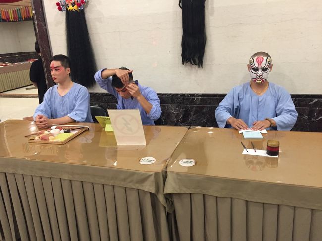 改めて周りを見渡すも、日本人ばかりだ。<br /><br />比較的客層が高い方々が多い気がする。<br /><br /><br />19:30になると、エレベーターで会場へ。<br /><br /><br />数々のサイトで紹介されているように、二胡の生演奏や役者の方々の生メイクを見ることができる。<br /><br /><br />また、京劇の衣装を着ることもできる。<br /><br />始めに着るのは恥ずかしいかもしれないが、ぜひさっさと来て写真を撮っておこう。<br /><br /><br />誰か一人が衣装を着ると、ほかのお客さんもわらわらと集まってくる。<br /><br />特に家族連れだと、<br /><br />「お父さんも着ようや」<br /><br />「わしゃそんなんえーわ」<br /><br />と、収拾がつかなくなり、なかなか順番が回ってこなくなる笑<br />