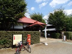 小平ふるさと村の正門です。
見えている赤い屋根は旧小平小川郵便局で、これまた小平名物？の丸型ポストが前に設置してありました。

http://kodaira-furusatomura.jp/
