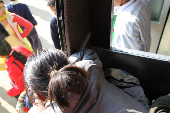 バスの中は身動きも出来ない状態。私は前方の席の窓側に座っていたが、日本のバスのシートと比べたらずいぶん狭い二人掛けのシートに3人。途中から乗って来た、子供を3人連れたお母さんが、突然4-5歳の女の子を大声を出しながら、私に「受け取って・・」っと来た。<br /><br />いやいや人身売買はヤバいだろ！<br />そこはピンと来て、女の子を受けとるや膝の上に置いて、窓から顔を出させた。その瞬間ゲロゲロ！・・・危なかった～<br /><br />その後もゲロゲロ状態なので、ずっと膝の上に置いて凸凹道を行った。暫くすると2歳くらいの妹まで私の膝の上に置く。W でゲロゲかよ！　と思ったら、おねいちゃんと一緒にいたい・・・ということらしい。<br /><br />この時はコンデジはリュックの中で、手元にはデジイチしかなかったので、こんな写真しか撮れなかった。