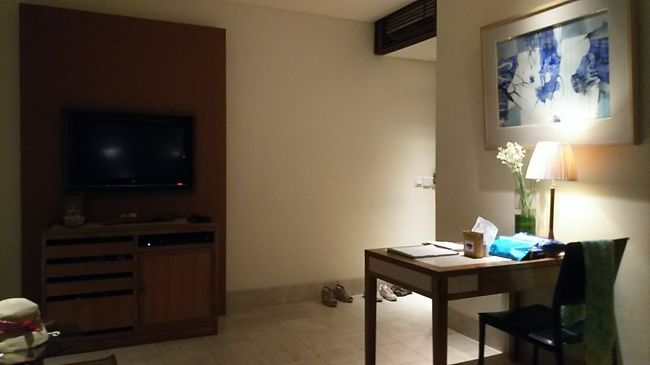 ベッド側からみたお部屋の様子。靴が置いてある右奥が入り口です。<br />テレビ下のキャビネットに冷蔵庫やお茶セットなど。<br />瓶に入ったクッキーと、フルーツも置いてあります。