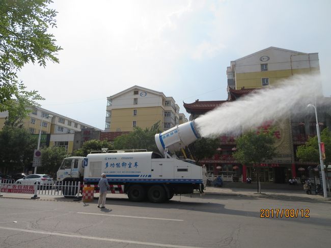街で見かけた「人工散霧車」。<br />こんな車初めて見た。<br />中国の街を歩いていると散水車を見かけることはある。<br />水を勢いよく横方向に放出し，汚れやごみを道端に飛ばしていく。<br />人々がトバッチリを受けないよう，必ず軽快な音楽を警報として鳴らしながら運行している。<br /><br />しかるに，この車は斜め後方に霧を盛大に放出しながら走っている。<br />この霧が歩いている私にも少し降りかかってきて，それがヒンヤリとして気持ちよかったので，最初はそういう目的かと思った。<br />しかし，この車の目的は，どうも空中に浮遊する有害スモッグ対策にあるらしい。<br /><br />