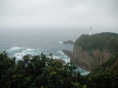 遊歩道を進み展望台から灯台が、小雨模様で風も強く水平線はよく見えませんでした。
「足摺岬郵便局」の風景印の図案と同じ眺めでした。
