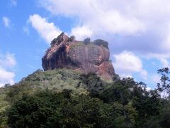 【シーギリヤ ロック（世界遺産）】

旅行3日目は、朝から、本ツアーのハイライト、世界遺産でもあるシーギリヤ ロックの観光に出発。

標高約370m、岩そのものの高さは約195m。
5世紀にカッサパ1世によって建造された、岩上の王宮跡。
一体全体なんでそんなところに王宮を…とお思いでしょうが、なんでも、このカサッパさん、クーデターを起こして父を殺して王権を奪取するんだけど、お母さんが一般庶民の出身。
このままじゃ、王族出身の母を持つ弟にいつか王位を奪われちゃうかも、とビビりまくり、首都であったアヌラーダプラを離れ、ここなら弟がせめてきても大丈夫だろうってことで、岩山の上に王宮を立てたんだって。

ま、結局、最終的には攻めてきた弟に負けて自害しちゃうんだけどね。
(なにこの韓流時代劇みたいなパターン(;^ω^)）

その後、都は再びアヌラーダプラへ戻るので、こちらは徐々に衰退。
王亡き後は修道院として1世紀ほど存在していたらしいけど、その後16世紀ぐらいまでは記録すら残されていないんだって。いやでも、良かったよね、カッサパさんに感謝しないとね。
今や世界中からこれ見たさ、登りたさに観光客が来るんだもん。