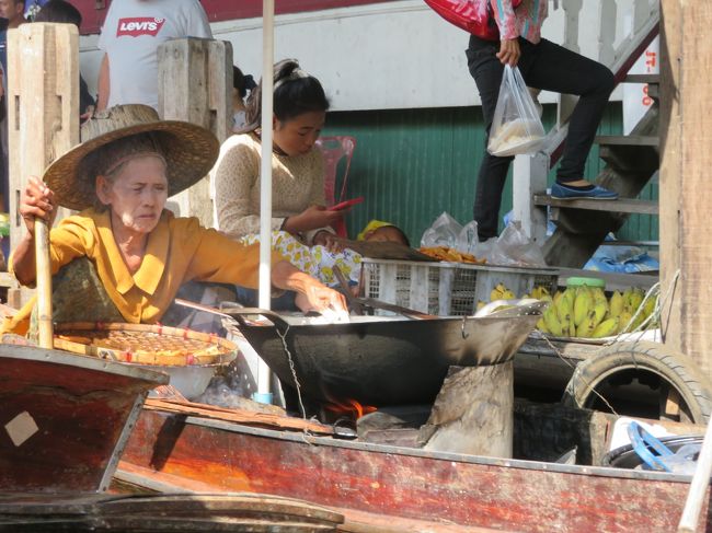 ボートの中で、おばあさんが何か煮炊きしてます