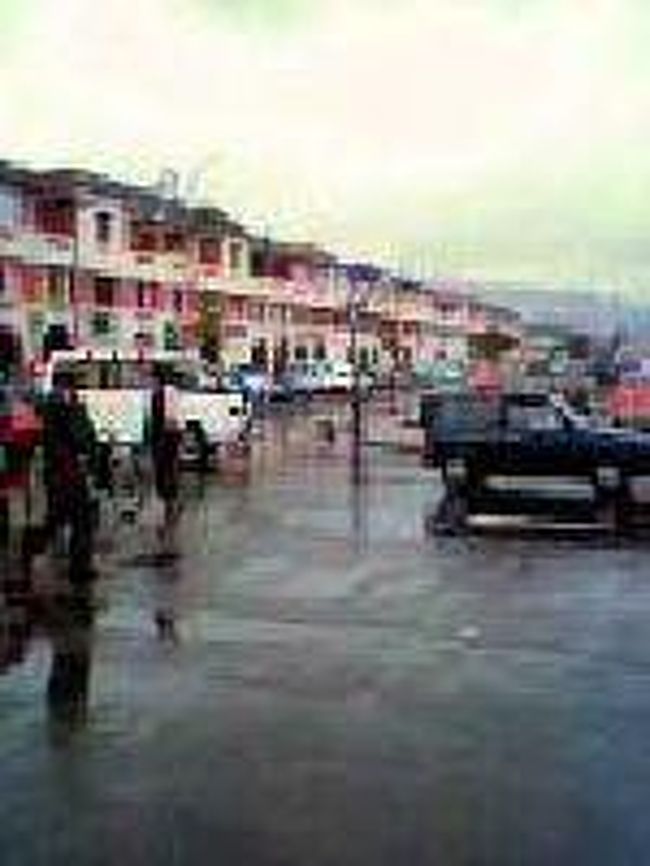 [２００７/３/１７]　(駅前の大道り)<br /><br />鉄道駅を背に独立大通りを見ています。通りを挟んで建物が並んでいます。1階は1部アーケードになっています。左手角の両替所の前では闇の両替商の人がたくさんいます。さらに進んでいくと、エアフランスやエアマダガスカルのオフィスの前ではお土産を扱う露店のようなものがたっています。 