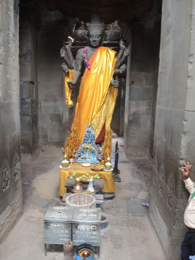 西塔門の右手にはヒンズーのヴィシュヌ神が祀られています。<br /><br />このことからわかるように、アンコール・ワットは、12世紀当時東南アジア世界で一般的だったヒンズー経の寺院です。<br /><br />＊＊＊＊＊＊＊＊＊＊＊＊＊<br />初期の王朝ではヒンズー教が主体で、寺院にもヒンズー教の伝説や神々が登場します。その最高到達点ともいえるのが、12世紀前半に造営されたアンコール・ワット。<br /><br />後期に入ると、平和を願う大乗仏教が勢いを増し、観世音菩薩など仏教のモチーフが登場。こちらの代表格が、12世紀後半に作られたアンコール・トム（バイヨン）です。<br /><br />ヒンズー教と仏教が混在した広大な遺跡群はこうして誕生しましたが、王族の中でも宗教戦争は激しく行われていました。【DTACカンボジア観光情報局HP】<br />＊＊＊＊＊＊＊＊＊＊＊＊＊＊<br />