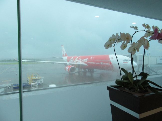 となりに　さっき到着したAIR ASIA<br />そして大降り　(/ω＼)<br />折り畳みの傘ではしのげませんよ。