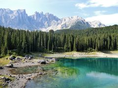 トンネルを抜けるとそこには神秘的な湖がありました。
エメラルドグリーンの澄みきった湖です。これがカレッツァ湖、言葉が出ないほど美しい湖に感動しました。
早朝のためか観光客が少なかったので、メンバー全員でこの素晴らしい景色を満喫しました。
ただ背後のラテマール山は太陽の光を反射して白っぽく輝いていたため写真にすると山の稜線がボケていました。
光線の向きの関係で午後の方が写真映りがいいそうです。当然山も湖もくっきり見えてまさに絶景をみるなら午後がお勧めとのこと。私たちは時間刻みで旅程が組まれたツアー客なのでどうにもなりません。
個人手配で行かれる方は午後の素晴らしい景色を堪能してください。またコルティナダンペッツォ発でのドロミテ街道観光なら、カレッツァ湖の観光は必然的に午後になるので、最良の景色に出会えると思います。

