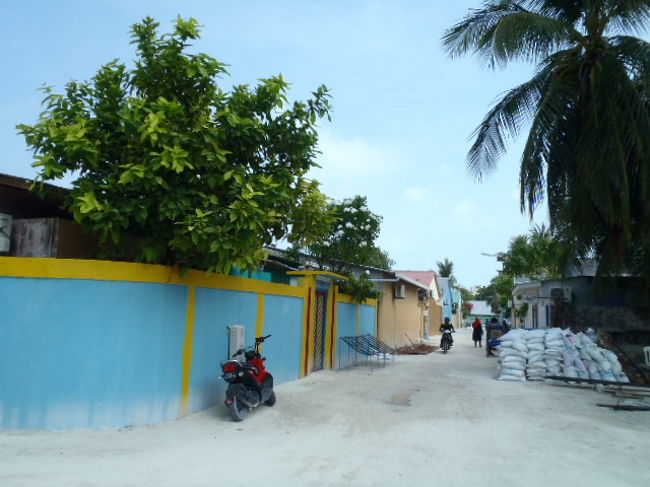 Maafushi島の住宅居住地はカラフル。<br />ブルーのカラーの塀に黄色縁取りの家に白砂の道路。<br />オシャ～レ・・・