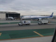 快適だった9時間55分のファーストクラスのフライトも終わりに近づき、ロサンゼルス国際空港のRWY24Rに着陸。
ターミナルまでのタキシング中、格納庫に駐機中のアメリカン航空B787や後から着陸した同じく成田発ANAのB777-300ERが到着し、JAL機の後ろに続きます。
3度目のロサンゼルス国際空港は、1回目は仁川経由の大韓航空B747-400（乗るんじゃなかったとと思った…）、前回のJALのB787-8、そして今回もう慣れたました。

10：07に定刻より7分遅れで155番搭乗口に到着。

降機する際のBGMは、搭乗時と違い、スタジオジブリのアニメなど手掛けた作曲家の久石譲さんによる「明日(あした)の翼」が使われています↓

https://www.youtube.com/watch?v=JfiKl_VRYWY

「明日(あした)の翼」を聴きながら、ドアが開くまで待ちます。
ドアが開き、ファーストクラスの乗客から優先的にL1ドアから降ります。
担当して頂いたベテランCAにお礼を言いました。
搭乗中に色々とご迷惑をおかけしたこともありました…


私事になり、また長くなりますのでスルーしていただいて構いません。
子供の頃は、学校の教師に見た目で判断し、やっていることで少し苦戦すると「無理だから…」と違う場所に追い出されを、社会人になる際も「この仕事では無理だと…」と言われ、冒頭の旅行記概要で搭乗した経緯の中で初めてJAL搭乗した際の沖縄・那覇までの修学旅行でも、とある事情を知っているのにもかかわらず、嫌がらせを受けられて学校と教師は苦手になりました。
何で教師ってまともな人いないんだろうって思うのは僕だけか!?…

今の会社に転職する際に面接でのちに配属された部署の女性の上司や、飲みに行った仲のいい歳上女性に上記在籍していた学歴をこそっと言うと「何で？」と言われましたが、家族や周りからみると見た目と学歴が合わないと思われたのでやっぱり学歴は無駄だったことは正しかったと改めて感じました！
今の会社に転職して難関の国家試験も一発で合格、普通の方でもやりたがらない一人で今回も含め2度も海外に行ったし、何でもかんでも見た目でできないからと判断するのは良くないと思う！
なので散々これは無理だと言った教師へファーストクラスに搭乗した写真とコメントを2019年の年賀状に載せて送りつけて見返してやろうと思います！
今回のファーストクラスに乗れた時、今までの努力が報われたと感じたフライトでした。

ちなみに旅行の中で修学旅行が一番嫌いです。
何百人の人と一緒に大勢で行って他人と寝泊まりもしないといけない、夜遅くまでうるさいし、日中は自由に行動できないしね。
修学旅行で沖縄に行った際に通り際に、おみやげを少しチラッと見ると「別行動しない！」とベテラン教師に言われるは…ただ単に数秒止まって見ただけなのにね…
修学旅行や団体旅行は色々と制限があるからね…
沖縄は旅行記を作成してますが、修学旅行より日帰りで行った時のほうが楽しかったです。
『日帰りで行く沖縄・那覇の旅！』
https://4travel.jp/travelogue/10890530

修学旅行以外では、新婚旅行も含め夫婦の旅行やお友達などと行くと気を遣わないといけないのと場合によってはケンカするみたいだし、う～ん…
まあ新婚旅行は、今の人生では色々と個人の事情があって無理だと思うので心配はしておりません。
あとは家族と行くと恥かしいor余計な行動をされる、欲しいグッズやお菓子も自分が食べたいのに「このお菓子orグッズ欲しい！」と言うと「要らない！」となって色々嫌になってくる…（※アナハイム・ディズニーランド・リゾートや東京ディズニーリゾートに過去実際あった出来事です！）
大人になって親と出かけると勝手な行動をされると「何してるだよ！」と親と子の立場が逆になり、怒ってしまいます。
誰でも子供の頃は親に怒られましたが、大人になると逆に子が親に怒ることはあるかと思います。
たまによく見かけます！
そういうこともあり、行きたい場所や欲しいおみやげなど自分で決めて揉め事も無く気楽で自由に行動できるので一人で行くのが一番いいかな！
一人旅最高！