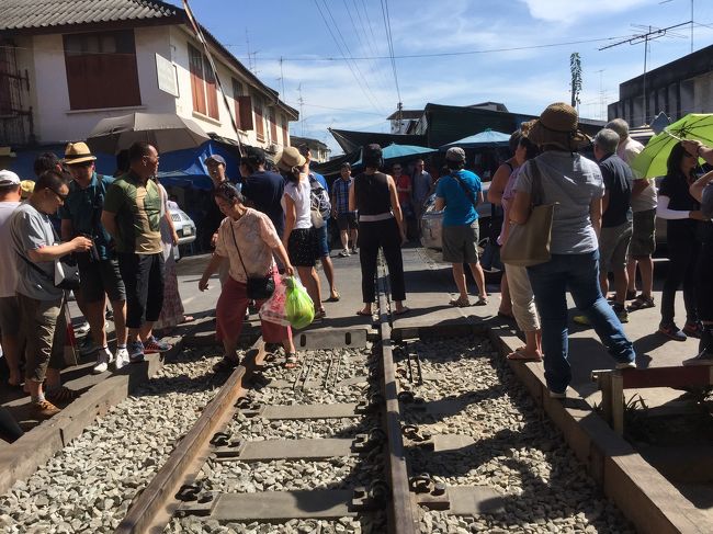 電車が来るのを待ち構える人々。