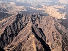 阿蘇五岳のひとつ，（鋸歯状の）根子岳 (1,433m)
約9万年前の巨大噴火後に活動した中央火口丘群の他の山とは異なり，根子岳は約15万年前に形成された。
(撮影日時 2018/02/24 14:45)

下記のURLで，阿蘇遊覧飛行の動画をご覧いただけます(5分26秒，音声付き，字幕をONにできます)。
https://youtu.be/9FRqqb2SmSY