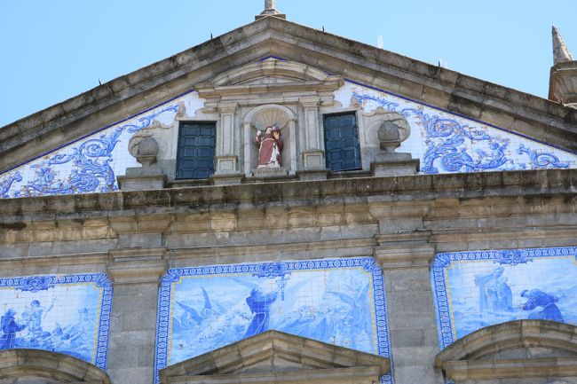 アズレージョは14世紀初頭にスペインのセビーリャから輸入したムーア人のタイルを起源とし、これをもとに16世紀からはポルトガル独自のタイルが制作され始めました。<br />ポルトガル建築の外壁や内壁に用いられ、装飾目的であると同時に、室温管理の機能も果たしているのだとか。