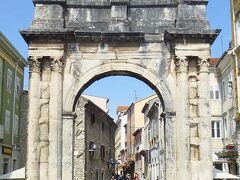 セルギウスの凱旋門（Slavoluk Sergijevaca（クロアチア語）、Triumphal Arch of the Sergi（英語）、セルギ門、黄金の門（Porta Aurea（ラテン語）、Zlatna vrata（クロアチア語）、Golden Gate（英語）））だ。
この門はセルギウス家（Sergius family（英語））*) 3兄弟、特にアクティウムの海戦（Actiaca pugna（ラテン語））（付録参照）で活躍し、オクタヴィアヌスの勝利に貢献したルキウス・セルギウス・レピドゥス（Lucius Sergius Lepidus）を記念して、BC27年頃建設されました。功績者として他にルキウス・セルギウス（Lucius Sergius）、ガイウス・セルギウス（Gnaeus Sergius）の名前が門に刻まれていますが、多分レピドゥスの兄弟と思われます。（私見です。）この門の建設に出資した女性として、レピドゥス妻：サルヴィア・ポストゥマ・セルギ（Salvia Postuma Sergia）が刻まれていますが、彼女はレピドゥスの妻、母、3兄弟の姉妹等諸説あり、本当の所は分かっておりません。
この門の裏側（西面）は様々なレリーフで美しく飾られていますが、ガイドさんは説明を省いてスルーしてしまいましたので、写真はありません。ご興味をお持ちの方は日本語ウィキ
https://ja.wikipedia.org/wiki/%E3%82%BB%E3%83%AB%E3%82%AE%E3%82%A6%E3%82%B9%E3%81%AE%E5%87%B1%E6%97%8B%E9%96%80_(%E3%83%97%E3%83%BC%E3%83%A9)
をご覧ください。説明文が正しいか否かの確認はしておりません。

*) セルギウス家は当地の強力な一家であり、彼らは何世紀にもわたって権力を保持していました。 
