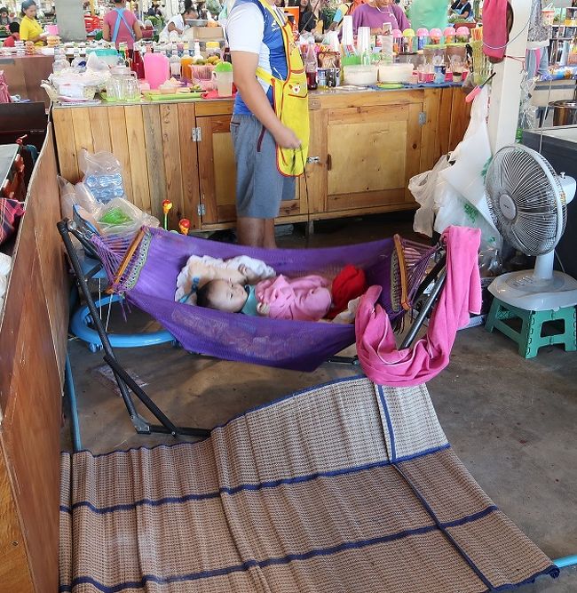 市場で仕事してる方の多くは収入が少ないです（儲からない）<br />時々見ますが子連れでの仕事です。<br />多分父親でしょうね右手に持っているのはハンモックお揺らす引き綱ですがタイ人のほとんどの人はガンガン揺らしますのでいつも心配しています【赤ちゃんの脳はまだ柔らかいのでゆっくり揺らしてください】