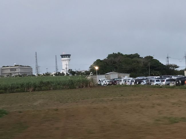 ツアーバスに乗って出発です。<br /><br />さすがに19時になり暗くなってきました。<br />さとうきび畑や牛が放牧されたりしていてのどかな感じです。<br />（この辺はそういう場所でした）<br /><br />向こう側に空港が見えます。<br /><br />これから石垣島鍾乳洞に向かいます。<br />こんな遅くに大丈夫かな～